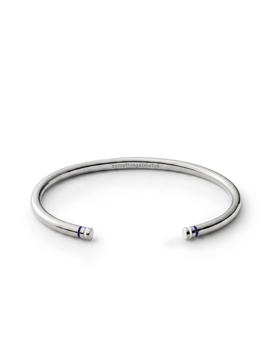 Polished sterling silver Blue Line Cuff with navy blue and white end details and engraved somethingaboutus logo.