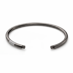 Black rhodium open cuff with parallel white enamel groove details near one end.