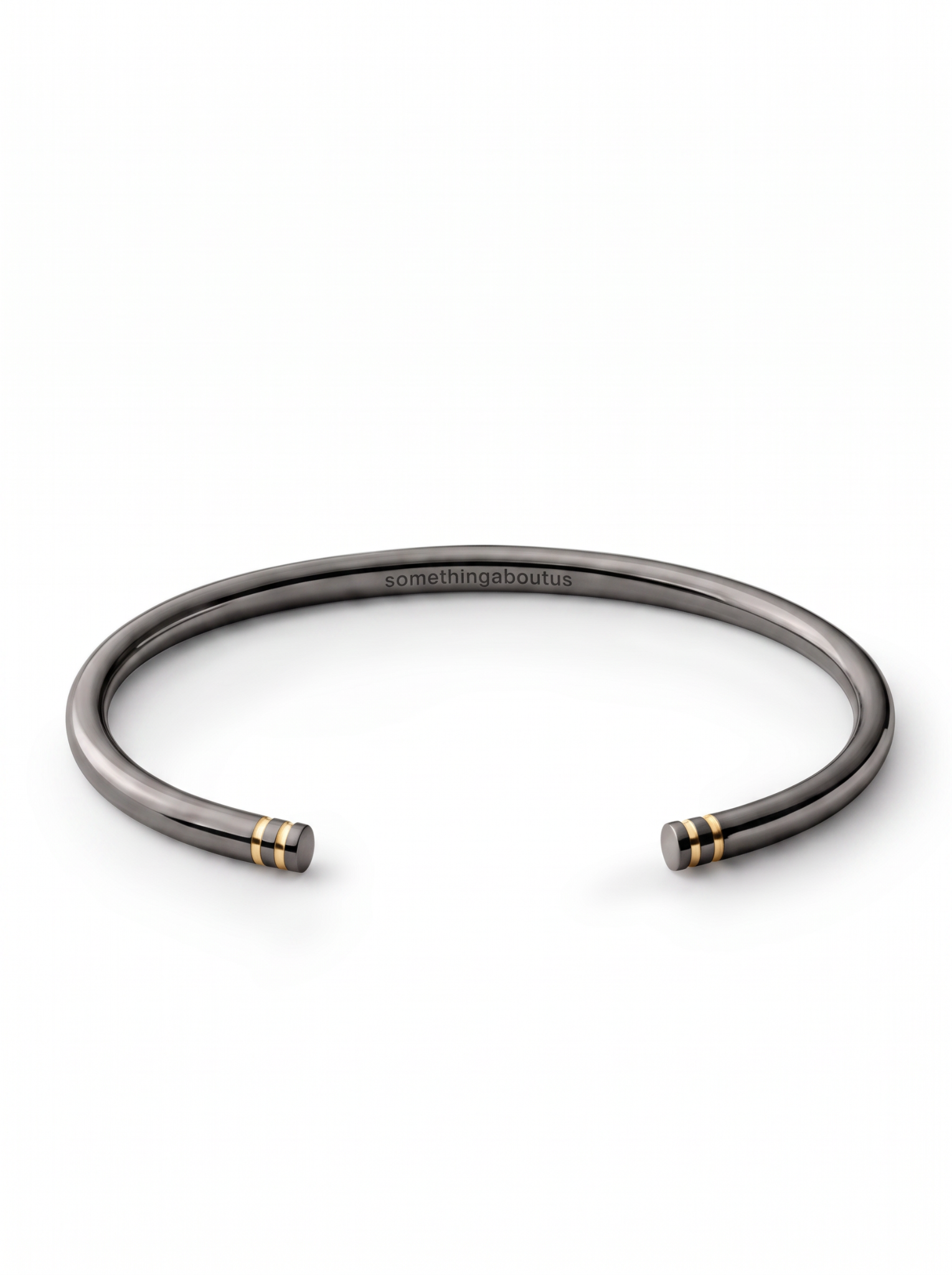 Black rhodium open cuff with twin gold-tone line details at each end and engraved somethingaboutus logo.